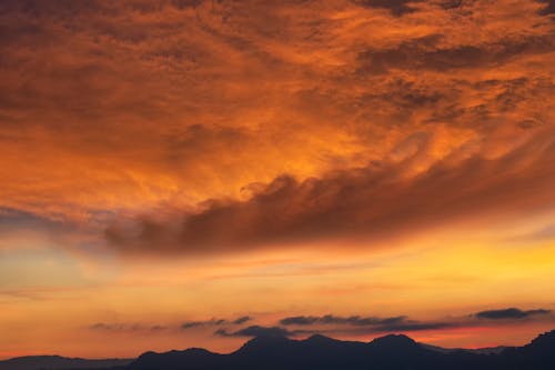 Orange Cloudscape and Mountains Silhouette
