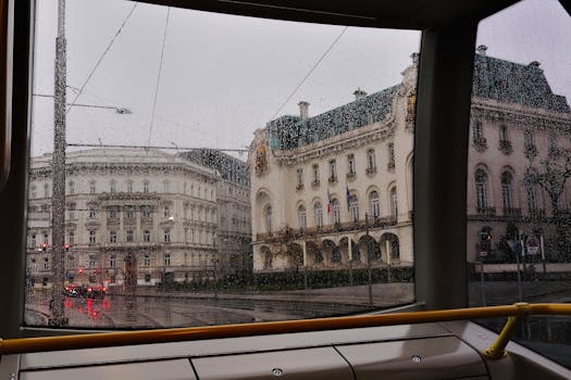View of Vienna's historic buildings through rainy tram windows, capturing the city's urban charm.