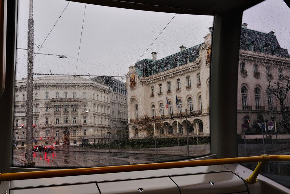 A modern red Wiener Linien tram moving through a street in Vienna, Austria