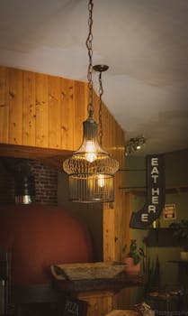 Warm and inviting café space featuring a rustic hanging lamp and wooden accents, perfect for a cozy atmosphere.