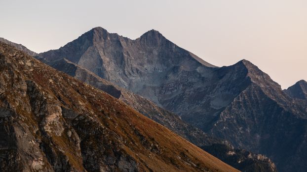 Breathtaking view of rugged mountains under the warm glow of sunset in Italy.
