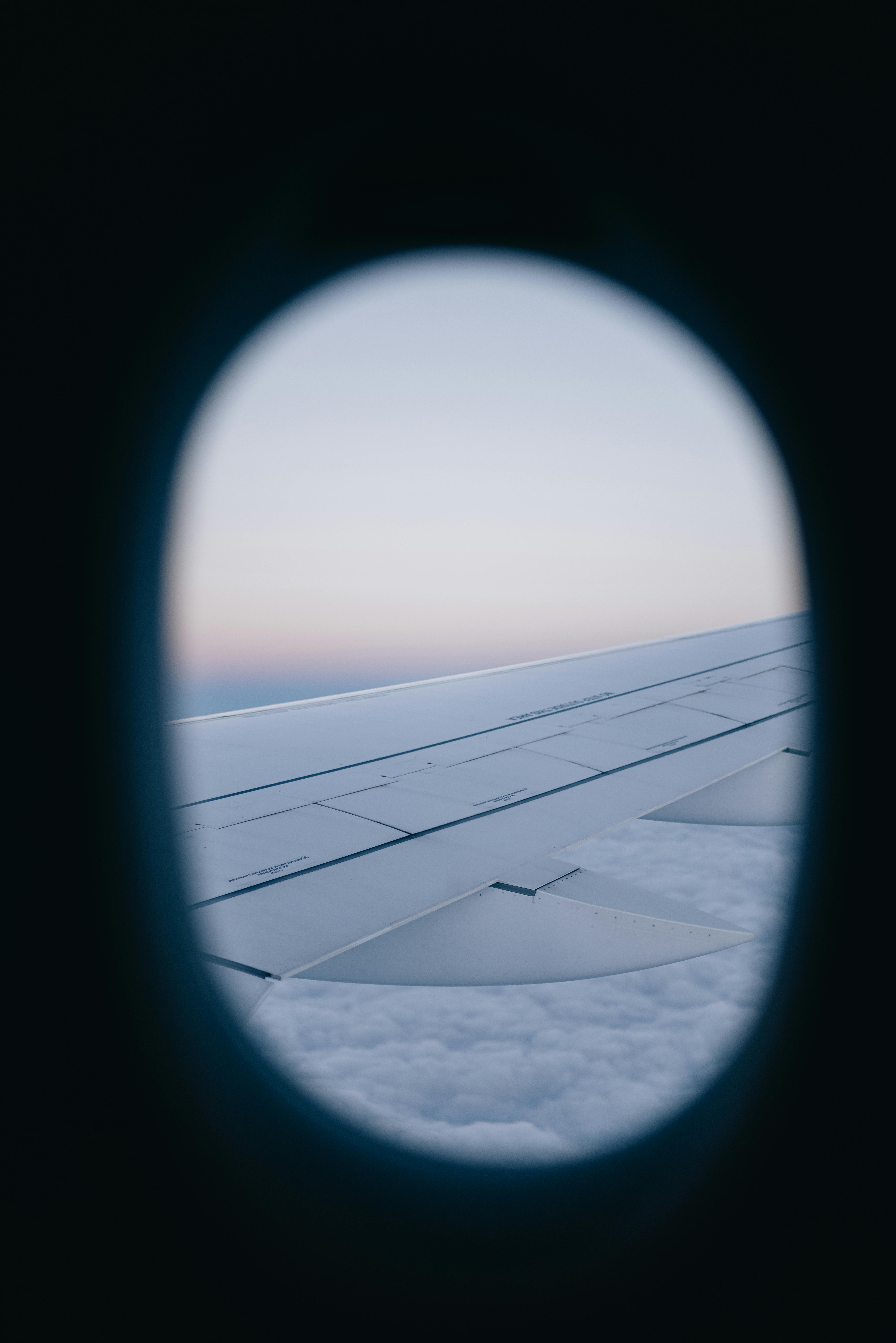 A serene view of an airplane wing through a window at dawn, capturing the essence of flight.