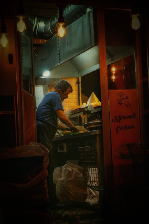 Free Late-night urban kitchen scene with a man preparing food outdoors in Bilecik, Türkiye. Stock Photo
