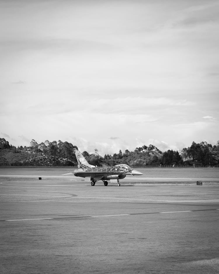 Black And White Photo Of A Military Jet In The Airport 