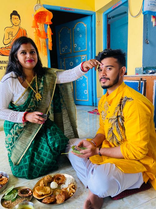 Free A couple performs a traditional Indian ritual with food offerings in a vibrant living room setting. Stock Photo