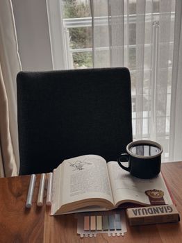 A peaceful study corner with an open book and coffee, perfect for reading.