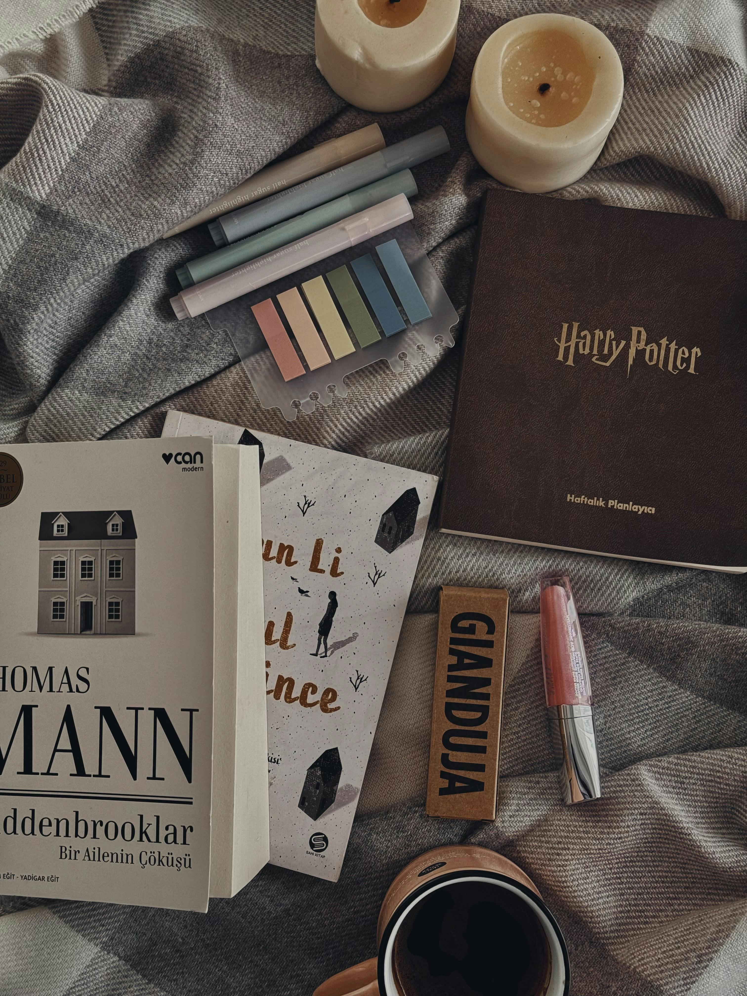 Flat lay of books, candles, and stationery for a cozy, study atmosphere.