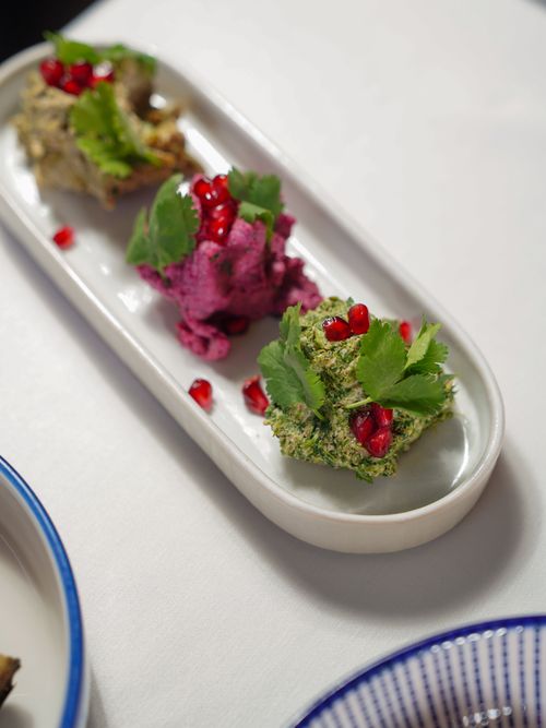 Free Vibrant vegan appetizers garnished with coriander and pomegranate seeds on a ceramic plate. Stock Photo