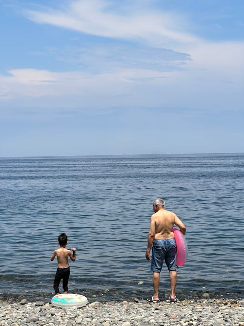 Man with Child Standing on Beach