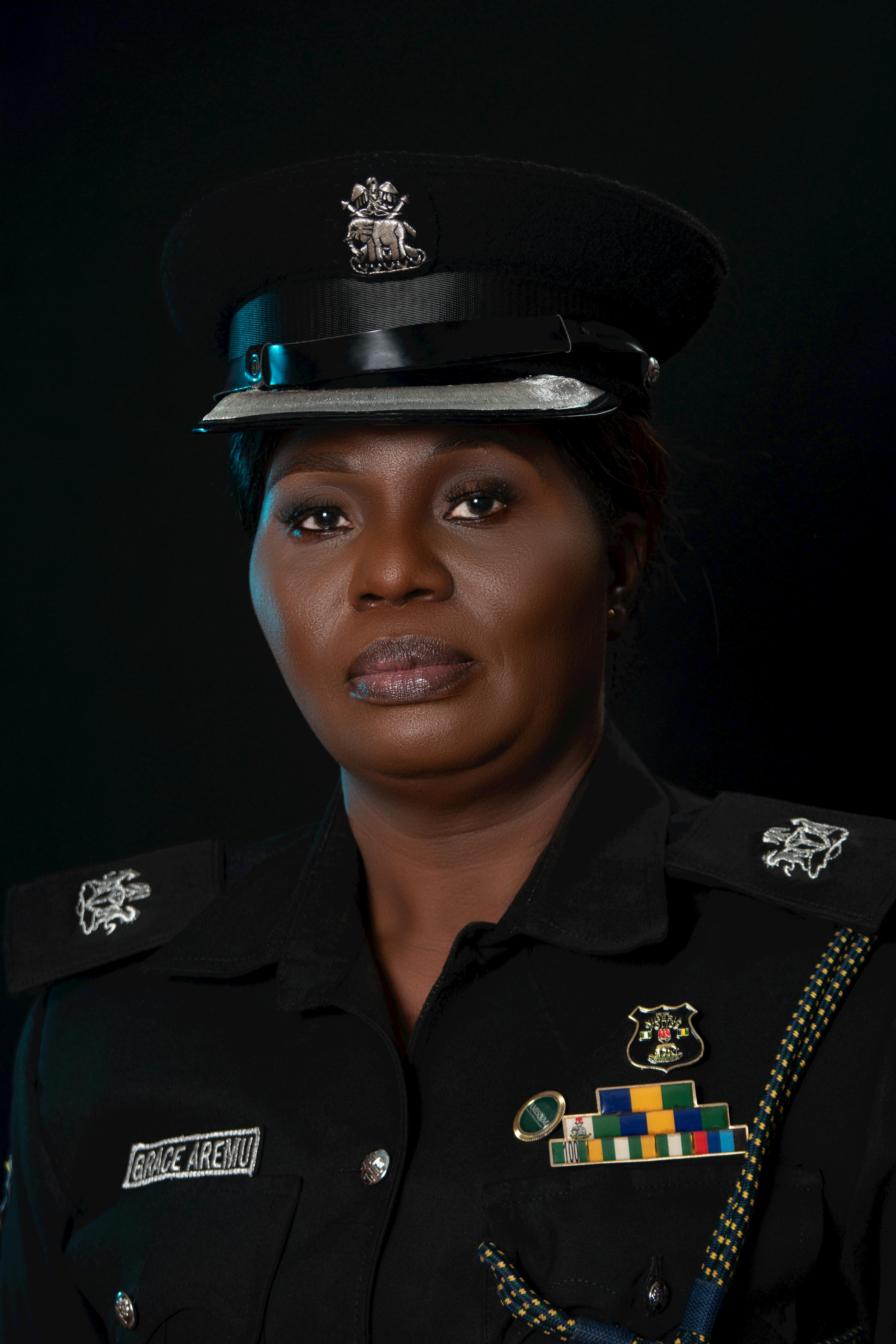 Professional portrait of a female police officer in official uniform against a dark background.