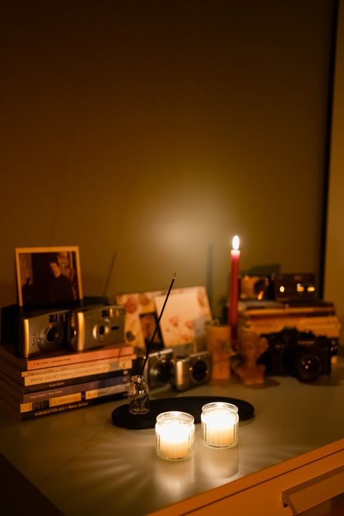 Free A warm candlelit scene with books and cameras on a desk in Ankara, Türkiye. Stock Photo