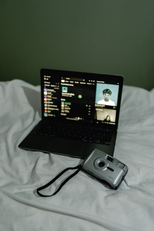 Camera and Laptop on Bed