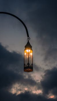 A glowing lantern illuminates the dusky sky, creating a dramatic, atmospheric scene.