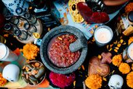 Colorful Day of the Dead altar with food, decorations, and candles in Guadalajara, Mexico.