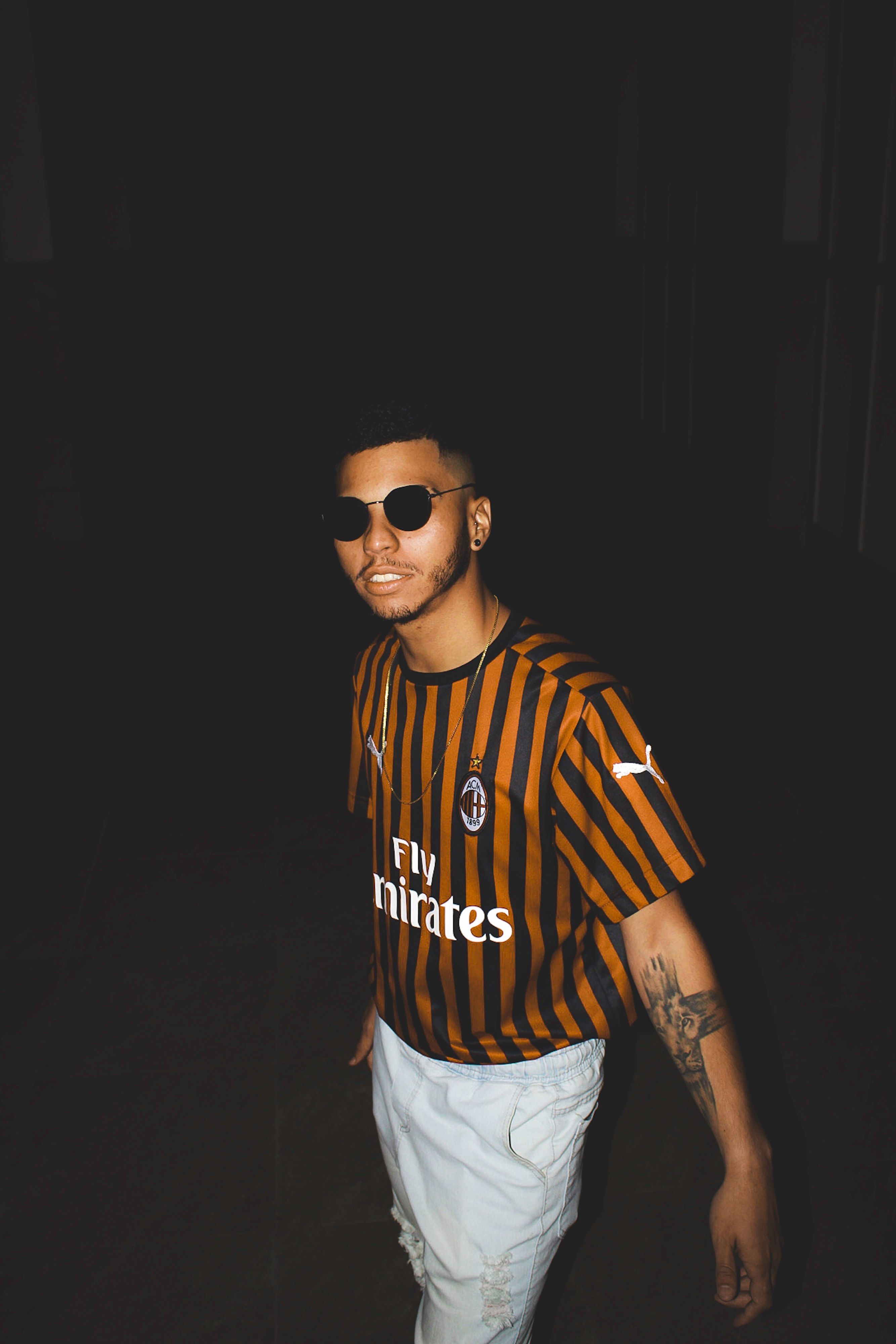 Stylish young man with sunglasses and tattoos in Brazil at night.