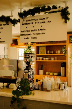 Warm indoor café setting adorned with Christmas decorations and event details.