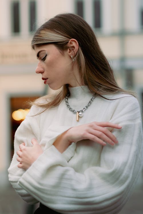 Young Woman in a White Sweater with Baggy Sleeves