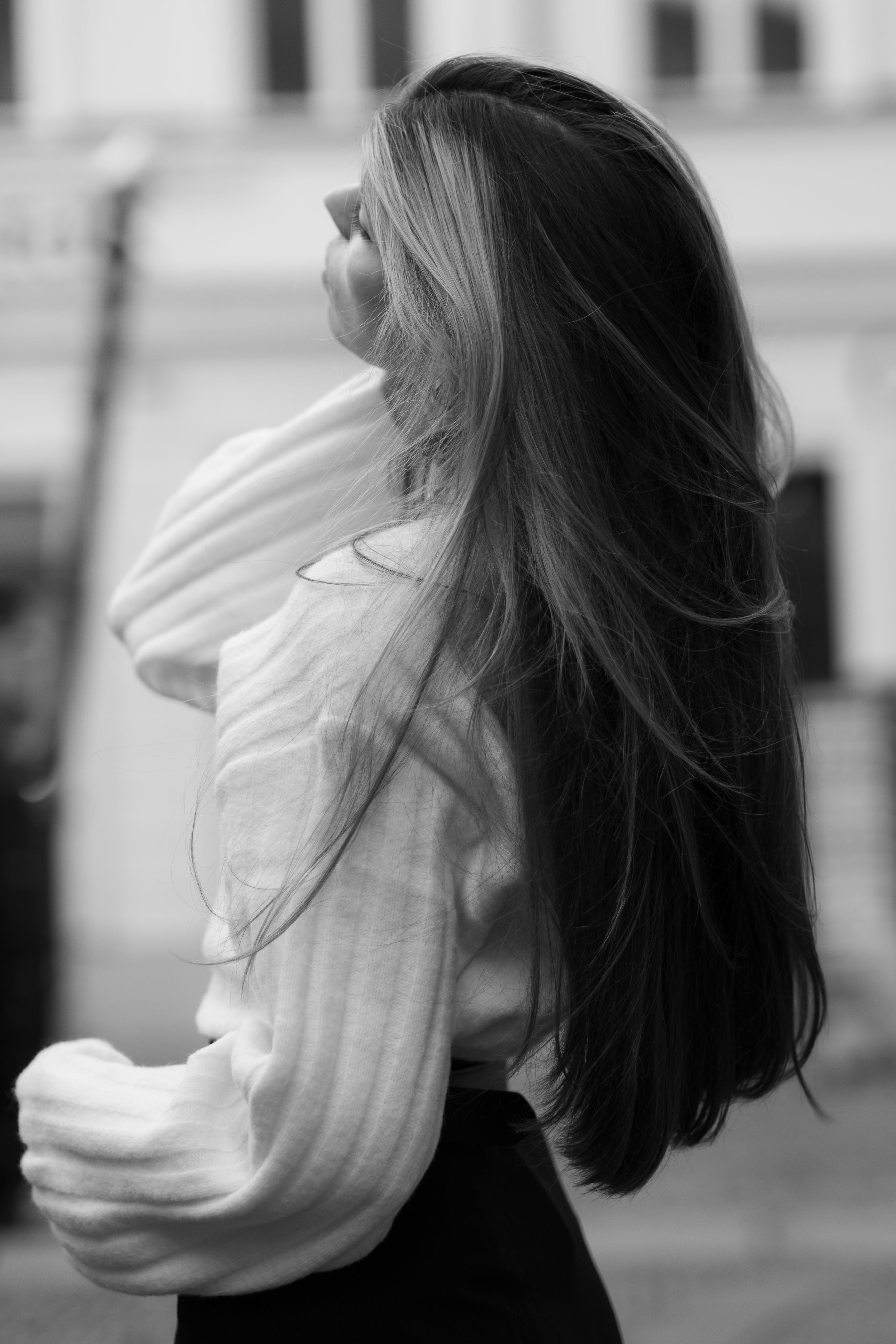 Black and white photo of a woman with long hair standing in Berlin, capturing elegance.
