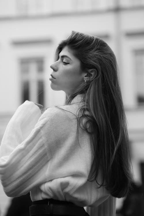 Black and White Photo of a Young Woman in a Sweater Posing Outside 