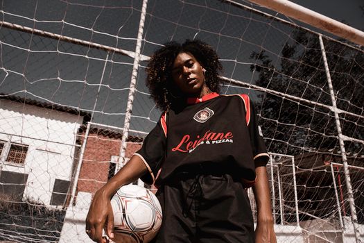Confident young woman soccer player posing in sports outfit on a football field in Mauá, Brazil.