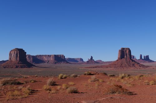 Free Breathtaking landscape of Monument Valley's iconic buttes and mesas under a clear blue sky. Stock Photo
