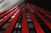 低角度视角下，引人注目的红色高层建筑与戏剧性的天空相映成趣