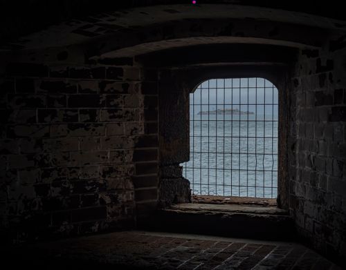 Free A dramatic perspective from a gothic dungeon window viewing the ocean beyond. Stock Photo