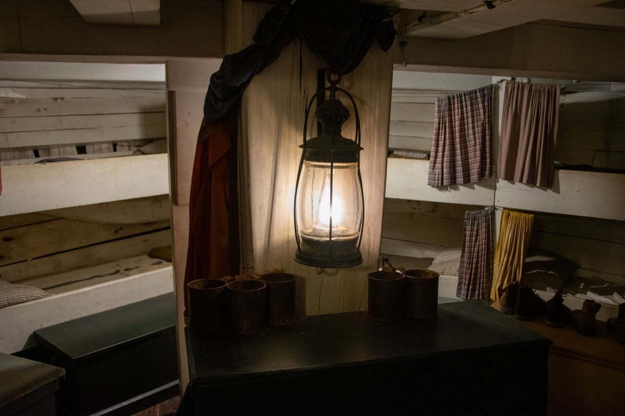 Lodge group bunk suite — wood-frame bunks under warm lamplight