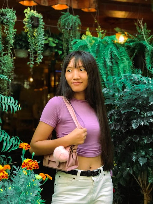 Woman in a Purple Crop Top and White Pants 