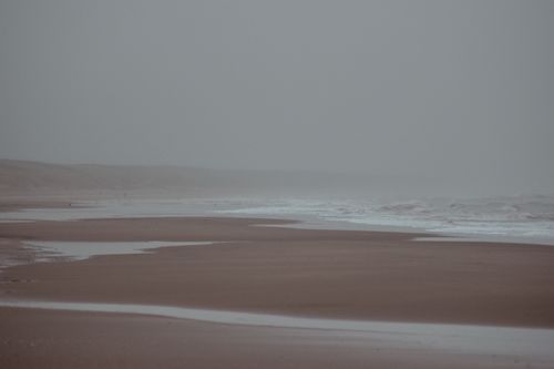 Free Serene foggy beach with misty waves and empty shore, perfect for calm and nature themes. Stock Photo