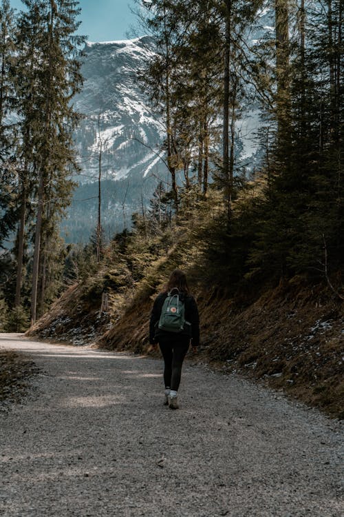 Woman with Backpack Hiking on Footpath