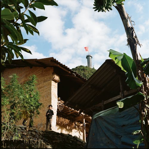 Boy near Walls of Village Buildings