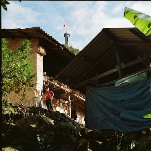 Boy Standing near Walls of Buildings in Village