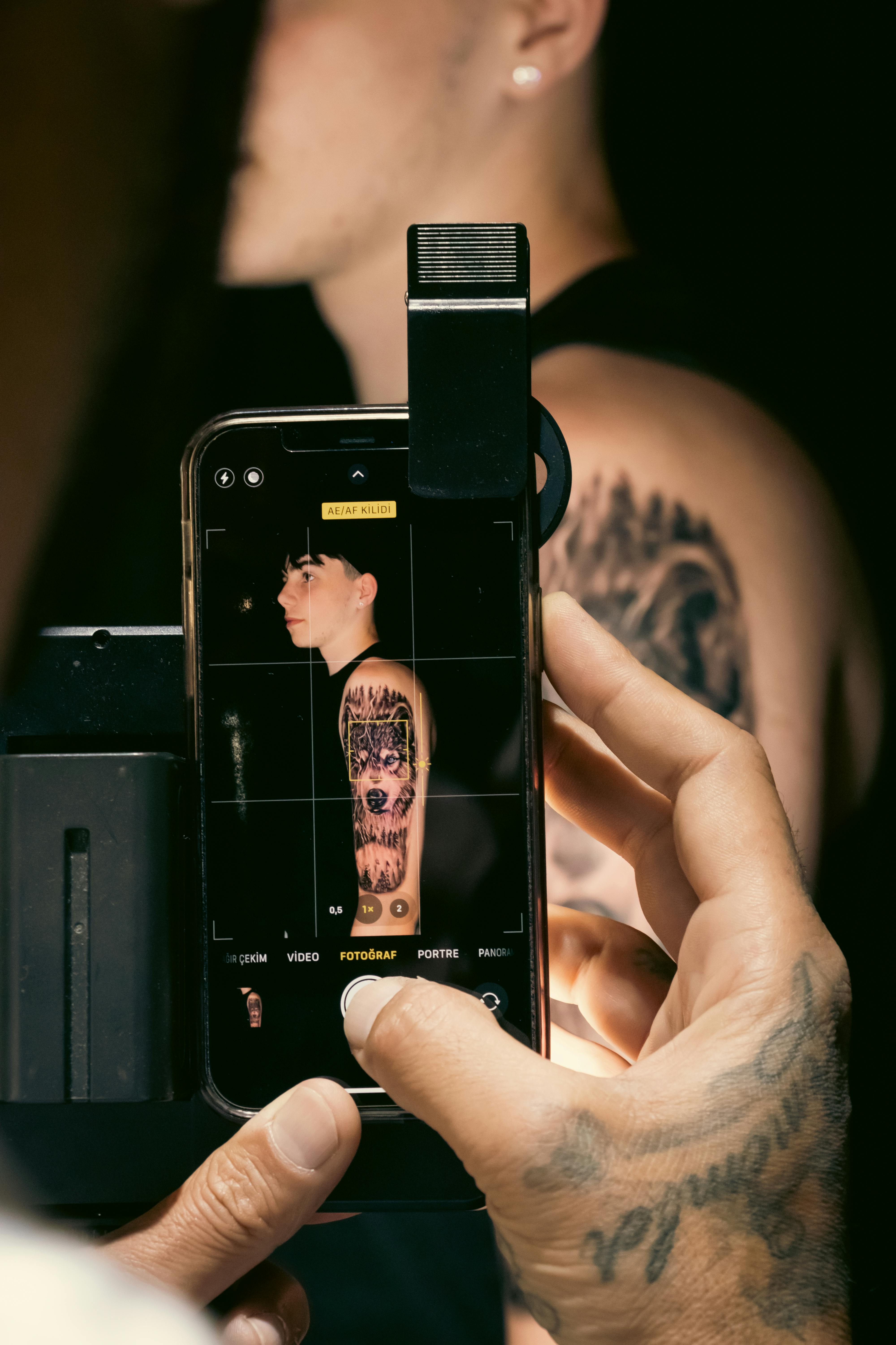 Free Capturing a tattooed arm with a smartphone in a studio setting. Stock Photo