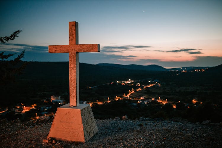 Cross On Hilltop Over Village