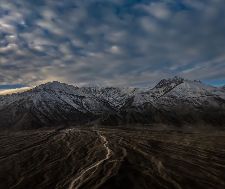 Explore the dramatic landscape of snow-capped mountains under a cloudy sky. Perfect for winter or travel themes.