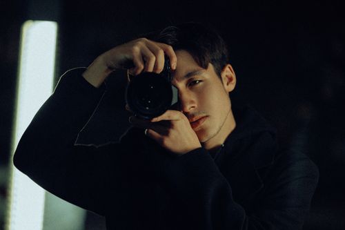 Free A man with short hair holds a camera, capturing photos at night in Muğla, Türkiye. Stock Photo