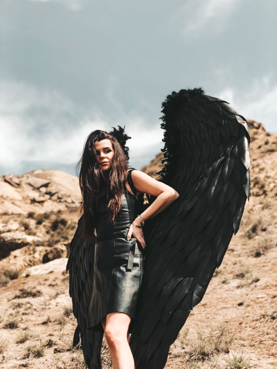 Model in a Leather Mini Dress with Black Feather Wings Among the