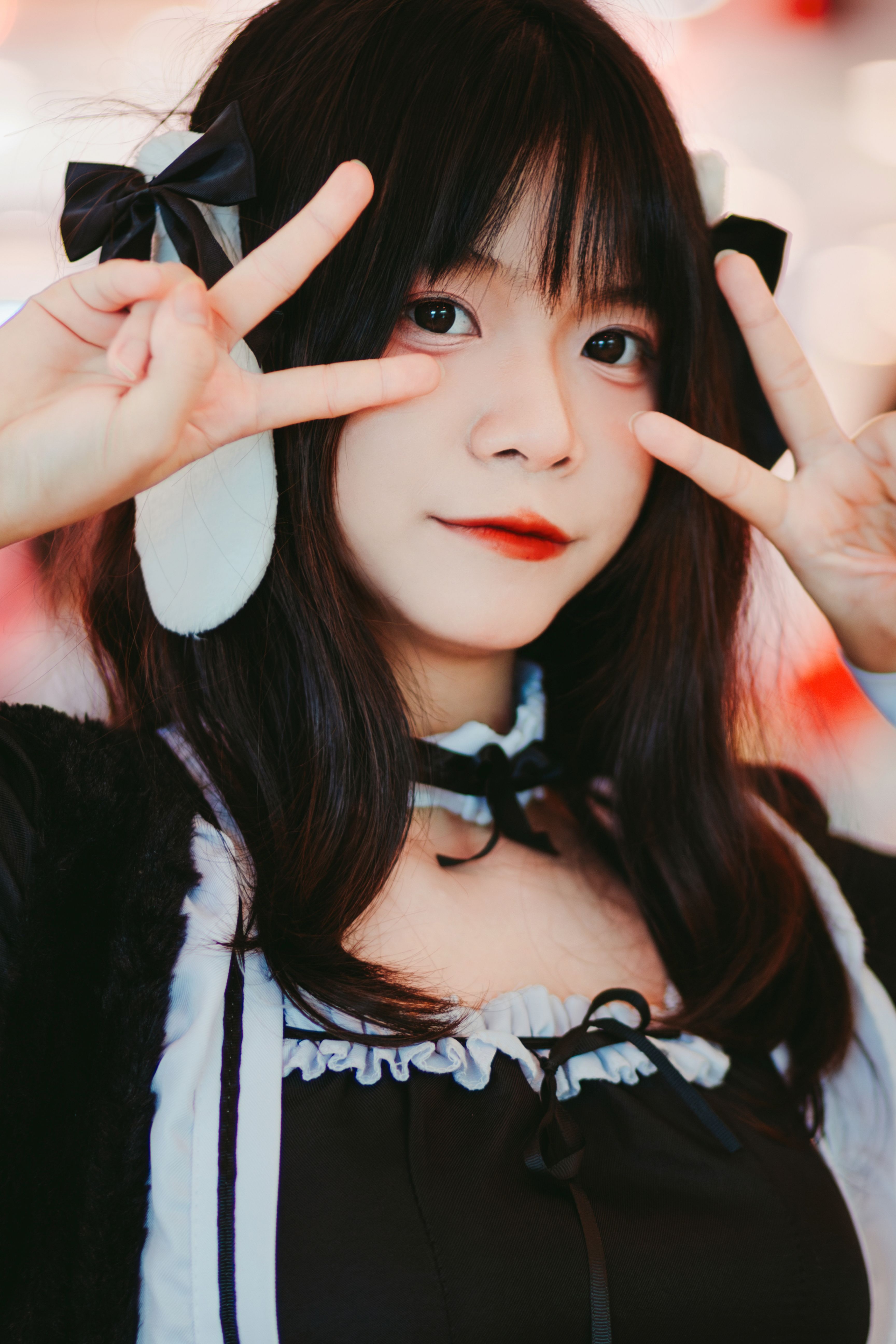 A young woman dressed in a maid costume poses with peace signs, exuding a vibrant and lively vibe.
