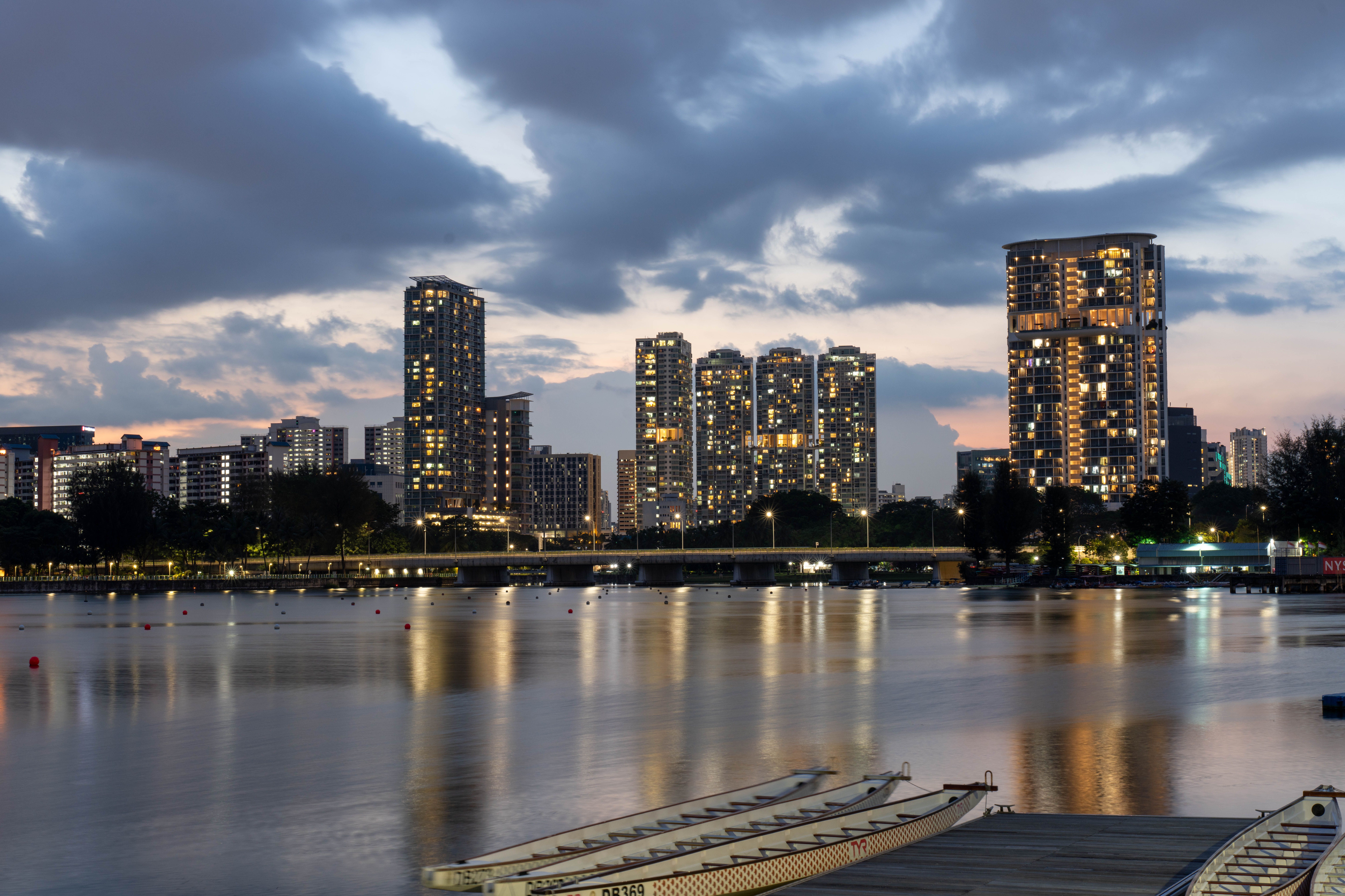 Illuminated Singapore high-rises reflecting on the waterfront, creating a vibrant cityscape at twilight.