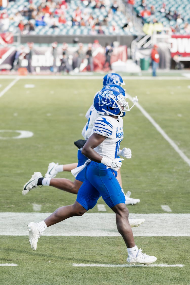 Memphis Tigers Football Team Players Running On The Stadium Field