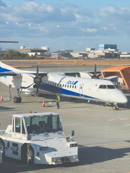 ANA turboprop aircraft parked at Matsuyama Airport in Japan, showcasing travel readiness.