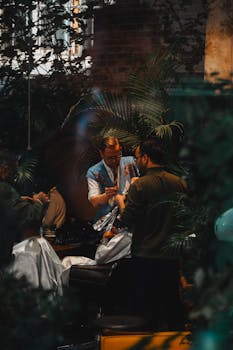 Barber working with client in a modern İstanbul salon amidst rich greenery.
