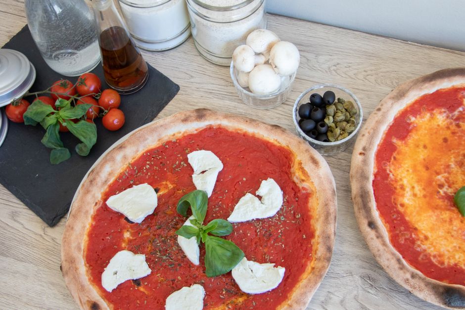 Pizza base with sauce, mozzarella, olive oil.