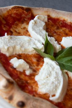 Close-up of a freshly baked Margherita pizza with mozzarella and basil.