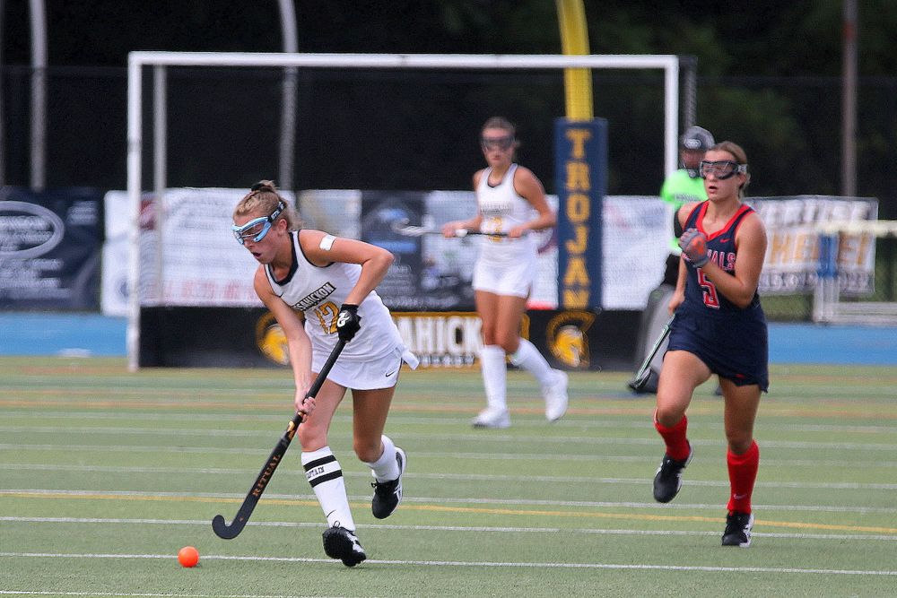 Field hockey team members competing in coordinated match kits