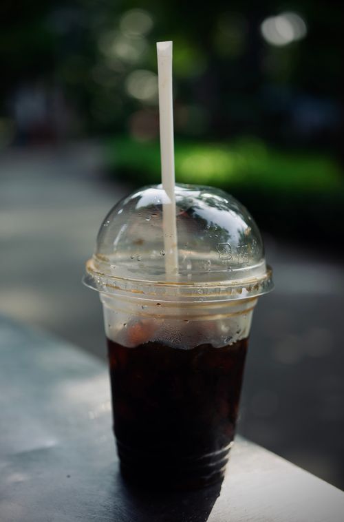 Free Close-up of a refreshing iced drink in a plastic cup with a straw, outdoors. Stock Photo