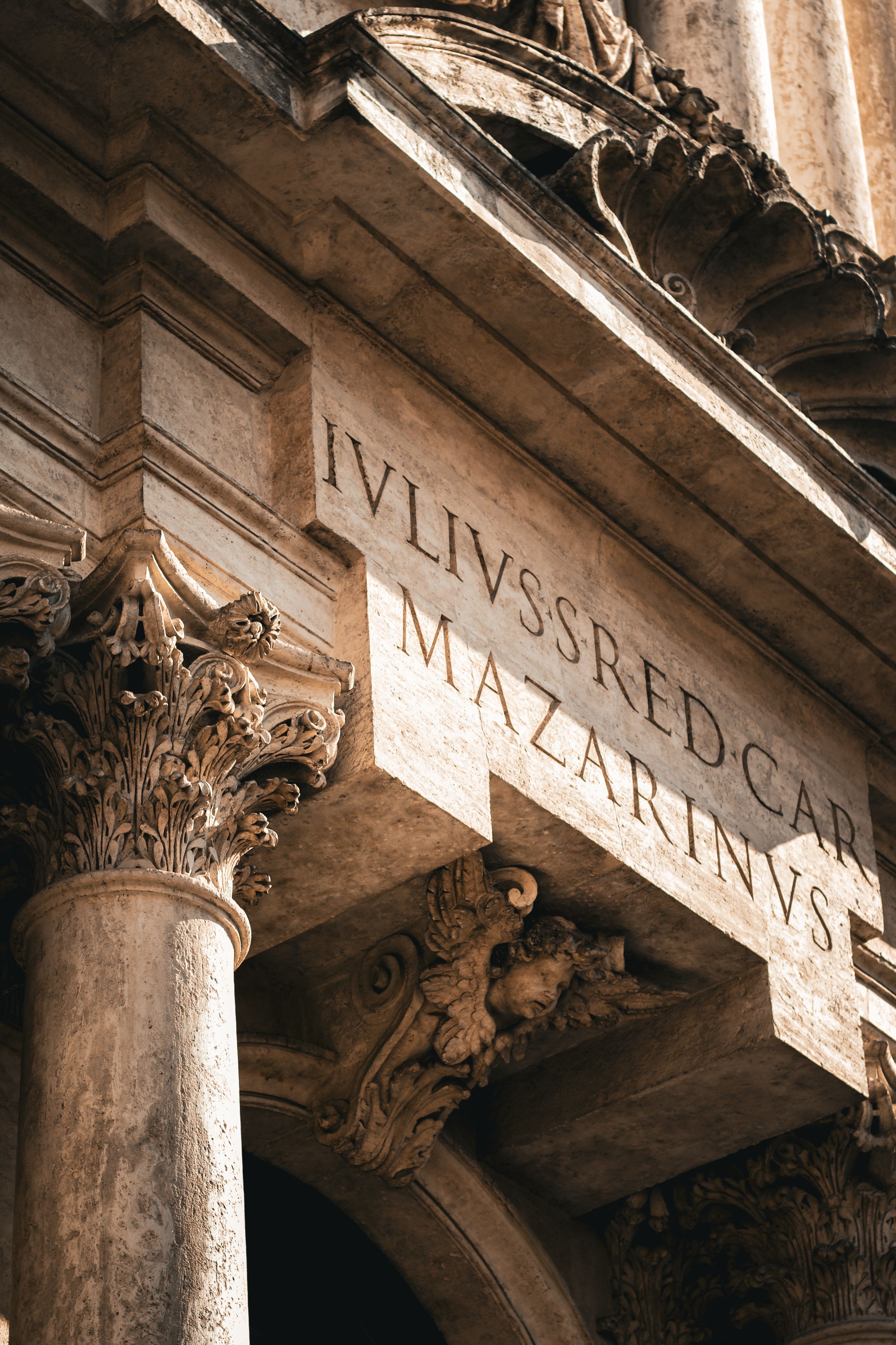 Close-up of ornate historical architecture with Latin inscription, capturing classical artistry.