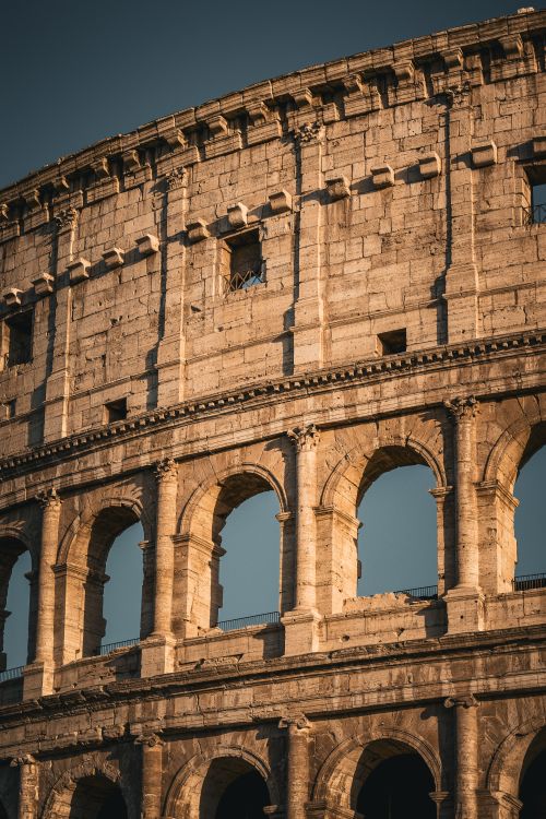 Free Close-up of the Colosseum in Rome, Italy, capturing its ancient architectural details in warm light. Stock Photo