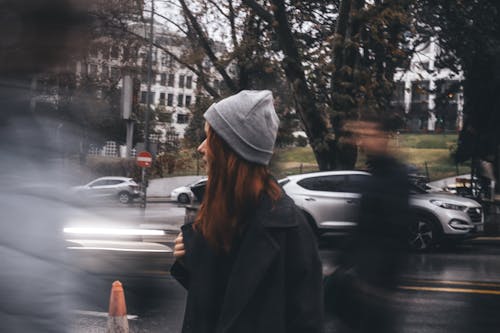 Woman Standing among Pedestrians on the Sidewalk 